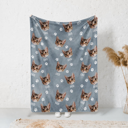 Blue personalized cat blanket displayed vertically with repeated tabby faces, name text, and paw prints