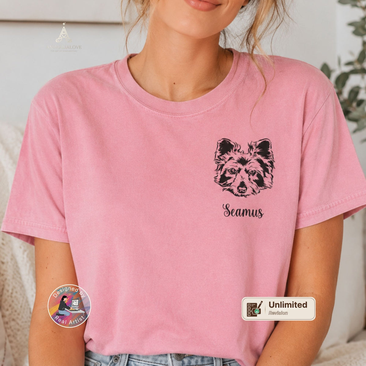 A woman wearing a pink crewneck t-shirt with a black line art graphic of a dog's head and the name 'Seamus' printed below it. The photo is cropped from the chin down, showing the fit of the shirt.