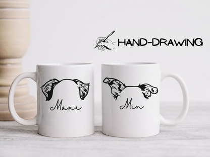 Two white ceramic mugs on a light surface, each printed with a black hand-drawn fish illustration and a script name underneath, one reading 'Maxi' and the other 'Min'. Above the mugs is a graphic with a hand drawing tool and the text 'HAND-DRAWING'.
