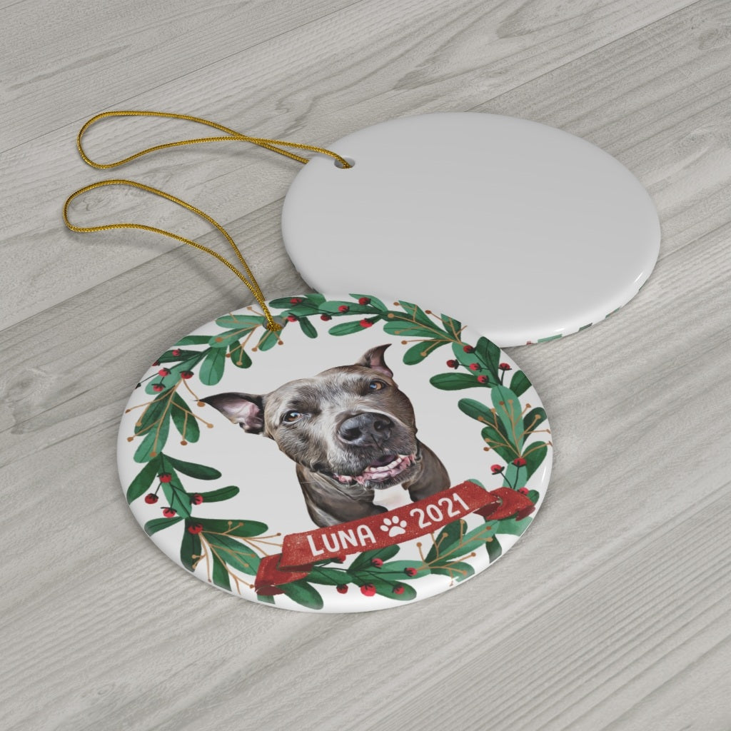 Personalized dog portrait ornament displayed with a blank ornament on a wood surface