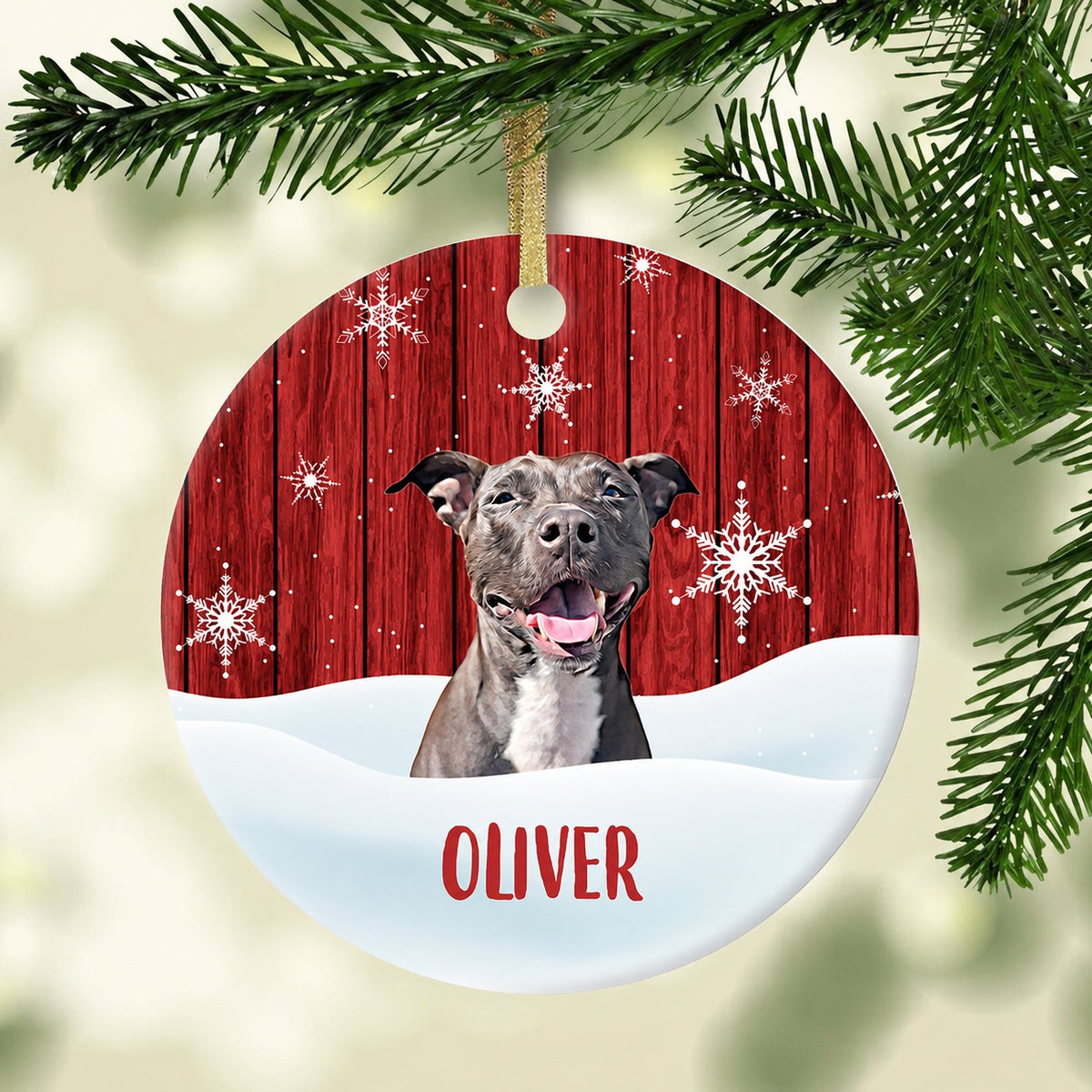 Round pet ornament showing a smiling gray dog in a snowy red woodgrain scene, personalized with Oliver