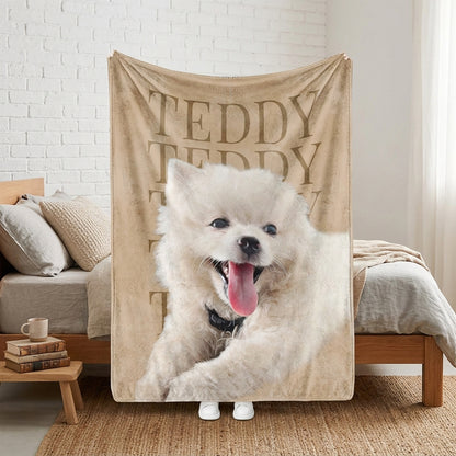 Personalized beige pet blanket featuring a fluffy white dog portrait and the repeated name Teddy