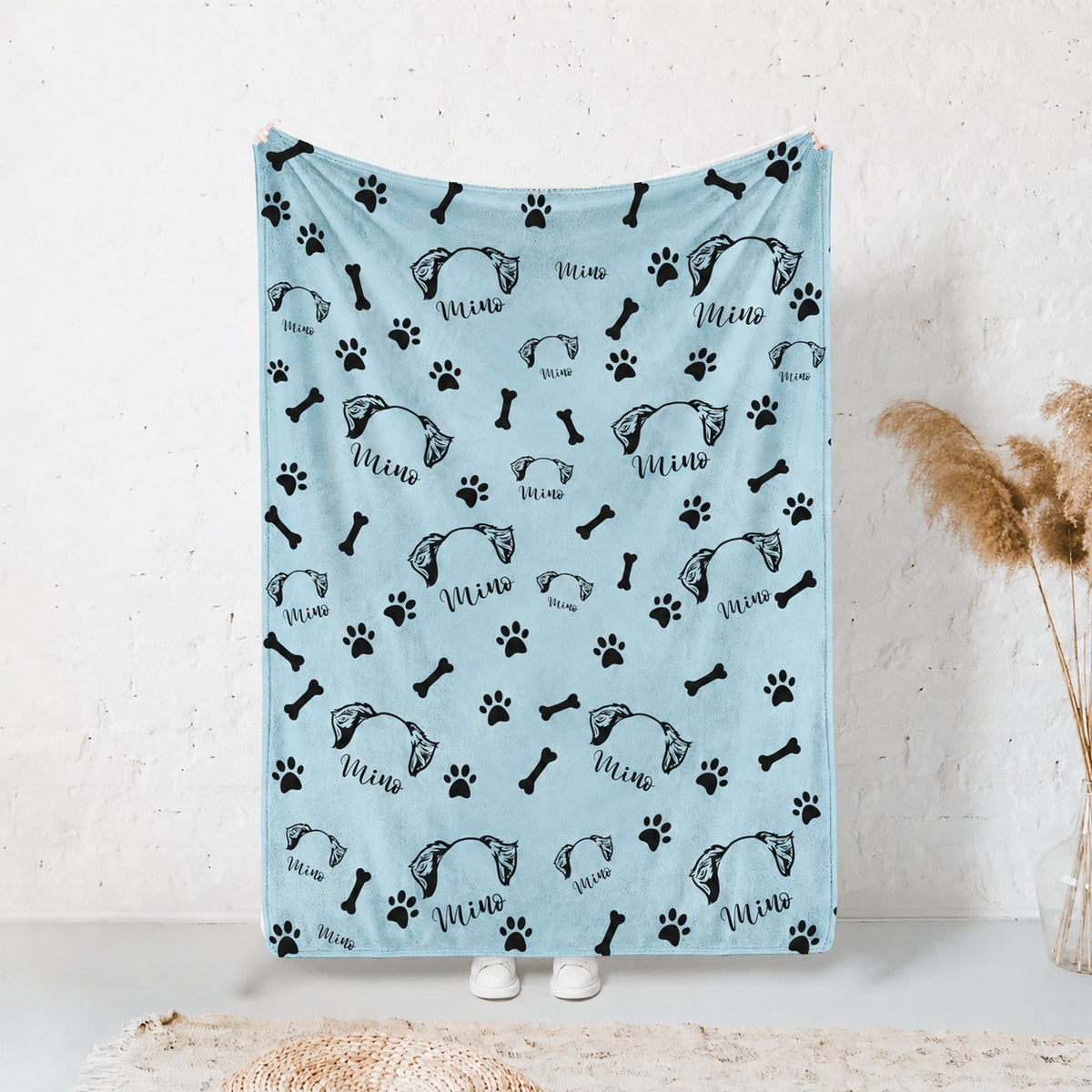 Blue personalized pet blanket displayed hanging with repeated pet ear artwork, the name Mimo, paws, and bones