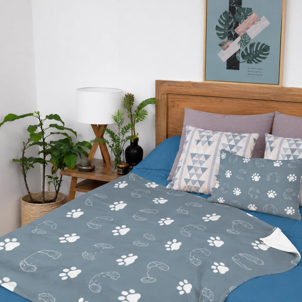 Gray pet blanket displayed across a bed with outlined dog and cat profiles and white paw prints