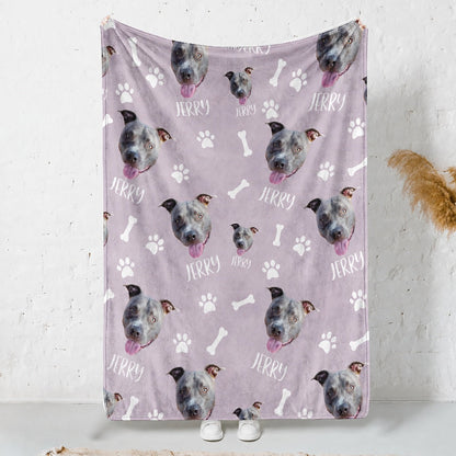 Personalized lavender blanket covered with repeated gray dog faces, the name Jerry, white paw prints, and bones