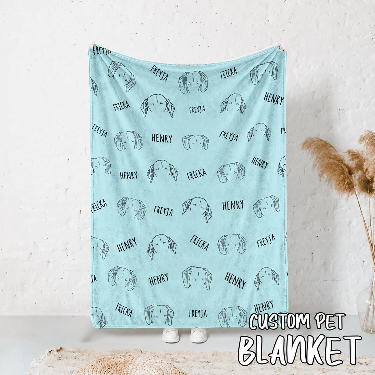 Blue pet blanket displayed upright with repeated dog face outlines and names Freyja, Fricka, and Henry