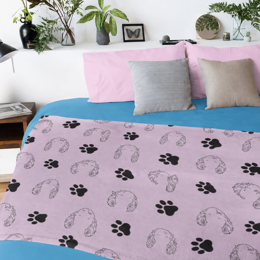 Pink custom pet blanket with floppy-eared dog outlines and black paw prints