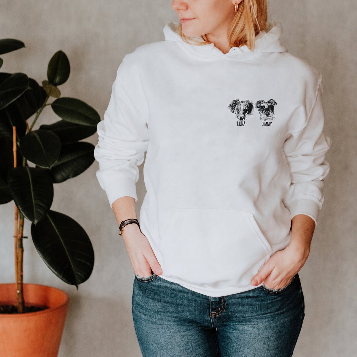 Woman wearing a white hoodie with two personalized pet sketches on the chest