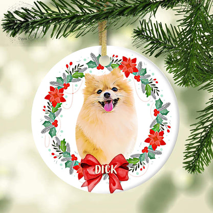 Personalized fluffy dog ornament hanging on a Christmas tree with holly, poinsettias, and a red name bow