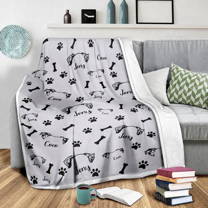 White personalized pet blanket draped over a sofa with repeated pet ear illustrations and names Jeny and Coco