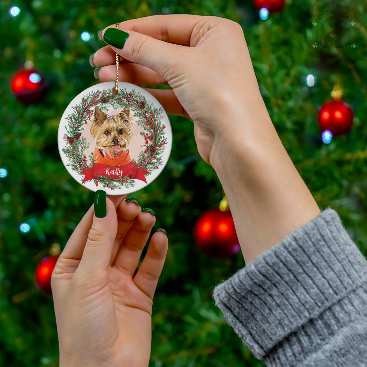 Round ceramic pet ornament featuring a Yorkie portrait, festive wreath, and Kathy name banner
