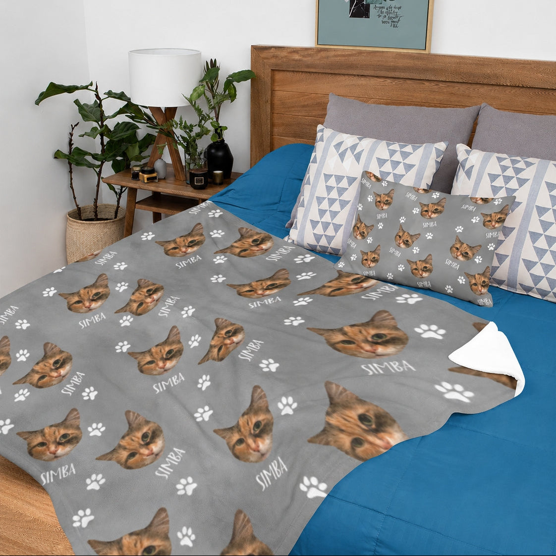 Personalized gray cat face blanket with repeated pet portraits, name text, and white paw prints on a bed