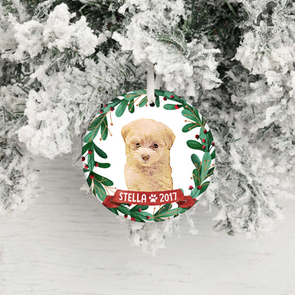 Personalized puppy ornament hanging against snowy branches with name Stella