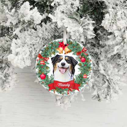 Round personalized pet ornament featuring a black and white dog named Bingo with holiday decorations