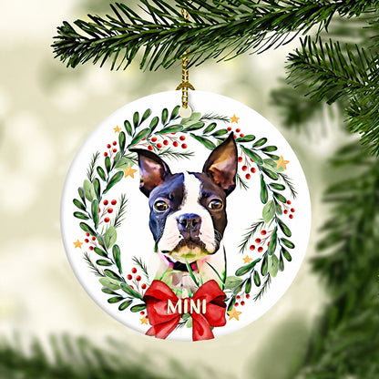 Pet portrait ornament featuring a Boston terrier surrounded by greenery, berries, stars, and a red bow