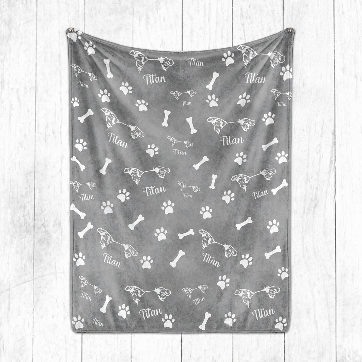Gray personalized pet blanket featuring white pet ear line art, the name Titan, paw prints, and bones