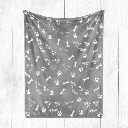 Gray personalized pet blanket featuring white pet ear line art, the name Titan, paw prints, and bones