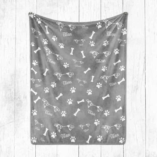 Gray personalized pet blanket featuring white pet ear line art, the name Titan, paw prints, and bones